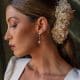 Perfil lateral de una modelo con recogido bajo luciendo los pendientes plateados Estefanía con estrella brillante y perla colgante.