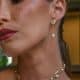 Primer plano de perfil de una modelo luciendo los pendientes dorados Ambas con detalle de perla y recogido bajo.